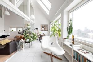 un soggiorno con sedia bianca e piante di 2ndhomes Gorgeous and Unique Top Floor Apartment with Sea Views and Sauna a Helsinki