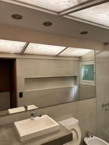 bagno con lavandino, servizi igienici e specchio di Cabaña La Morocha a Ostende