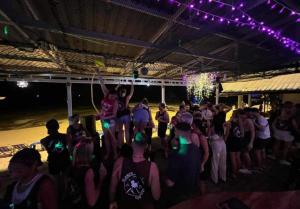 Un groupe de personnes debout dans une foule la nuit dans l'établissement Phi Phi Ocean Club, sur les Îles Phi Phi