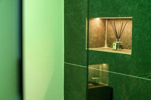un bagno verde con specchio e parete verde di Skia, Premium Key Collection a Città di Skiathos