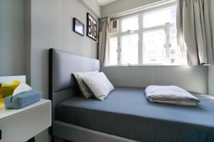 a small bedroom with a blue bed with a window at Student Accommodation - 294 Hennessy Road in Hong Kong