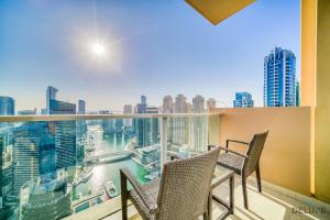 uma varanda com 2 cadeiras e vista para a cidade em Flawless 2BR at The Address Residences Dubai Marina by Deluxe Holiday Homes em Dubai
