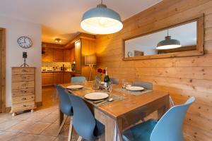 een eetkamer met een grote houten tafel en stoelen bij Appartement Belle Vue - Happy Rentals in Chamonix-Mont-Blanc