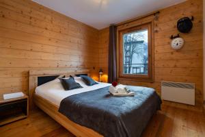 een slaapkamer met een bed in een houten kamer bij Appartement Belle Vue - Happy Rentals in Chamonix-Mont-Blanc