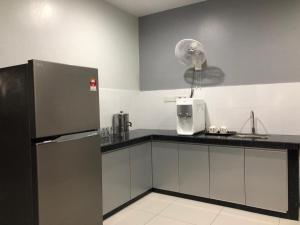 a kitchen with a counter with a refrigerator and a sink at L23 ,88 Resort Villa House in Pangkor