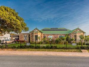 a large brick building with a green roof at Lilla-Bett Self Catering Accommodation Mossel Bay in Mossel Bay