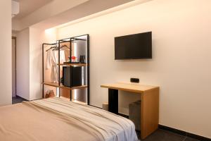 Schlafzimmer mit einem Bett, einem Schreibtisch und einem TV in der Unterkunft Skia, Premium Key Collection in Skiathos-Stadt