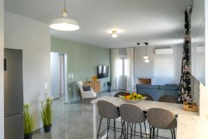 ヘルソニソスにあるNisimos Modern Apartmentのテーブルと椅子のあるキッチンとリビングルーム