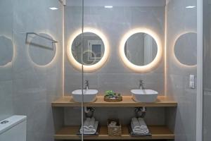 ヘルソニソスにあるNisimos Modern Apartmentの洗面台が3つと鏡が3つあるバスルーム +22枚の写真