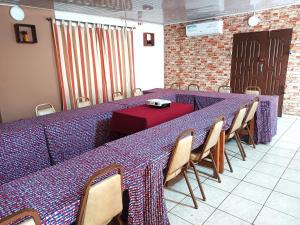 a long table in a room with chairs and a red table at Cloud9 Lomé in Lomé