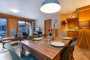 uma sala de jantar com uma grande mesa de madeira e cadeiras em Appartement Belle Vue - Happy Rentals em Chamonix-Mont-Blanc