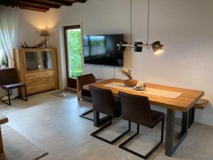 的住宿－NEU Ferienwohnung Waldecker Land，一间带桌椅和电视的用餐室