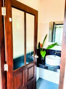 baño con lavabo y puerta en Mangrove beach house Sri Thanu, en Srithanu
