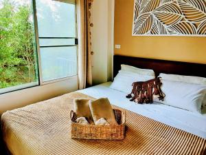 una cesta de toallas sentada en una cama con ventana en Mangrove beach house Sri Thanu, en Srithanu