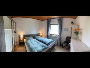 的住宿－NEU Ferienwohnung Waldecker Land，一间卧室配有一张带蓝色床单的床和一扇窗户。