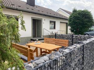 的住宿－NEU Ferienwohnung Waldecker Land，木屋前的木桌和长凳