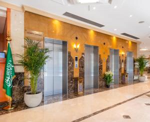 a lobby with elevators and potted plants at Emaar Al Noor in Makkah