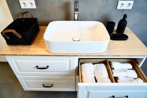 a bathroom vanity with a sink and towels at Zentral & Modern mit Parkplatz - 30 min bis zur Messe in Köln und Düsseldorf in Wuppertal