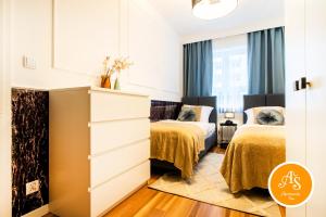 a bedroom with two beds and a dresser at ApartamentySnu, Wola Komfort IV z parkingiem in Warsaw