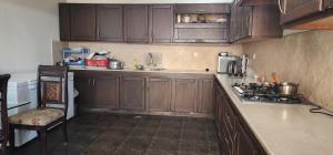 une cuisine avec des armoires en bois et un four à plaques de cuisson dans l'établissement Haven Resort Bhurban, Murree, à Bhurban