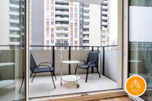 a balcony with two chairs and a table at ApartamentySnu, Wola Komfort IV z parkingiem in Warsaw