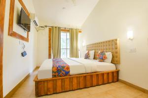 a bedroom with a bed and a window at FabHotel Grand Royal Palms in Benaulim