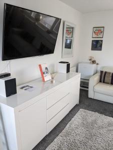 a white entertainment center with a large flat screen tv at Hawarden near Chester in Hawarden