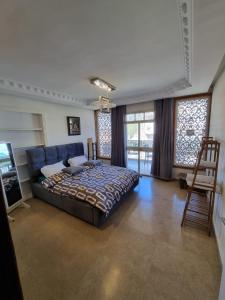 a bedroom with a bed and a chair and windows at Diamond Luxury Apartment - Haifa in Haifa