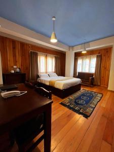 um quarto com uma cama, uma secretária e uma mesa em Norbu Healing Hotel em Thimphu