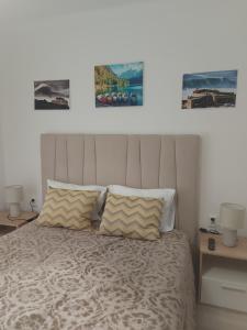 a bedroom with a bed with two pictures on the wall at Nazaré Holidays in Nazaré