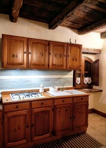 una cocina con armarios de madera y fregadero en Domus Claudia, en Castiglione in Teverina