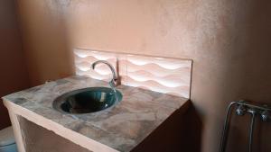 bagno con bancone in pietra e lavandino di Mhamid yaya camp & activités a M'Hamid