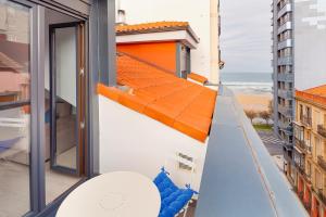 an apartment balcony with a view of the ocean at Ático con terraza en playa de San Lorenzo in Gijón