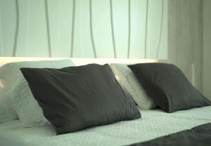 ポルト・ダ・ポリェンサにあるSivella Apartamentoのベッドの上に置かれた2つの灰色の枕