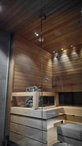 uma sauna com paredes de madeira e uma parede de vidro em LuxLapland Cranberry Levi em Levi
