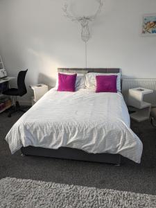 um quarto com uma cama grande e almofadas cor-de-rosa em Hawarden near Chester em Hawarden