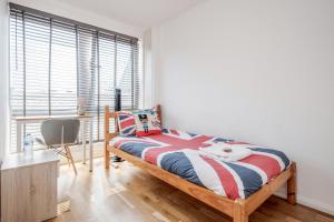 Schlafzimmer mit einem Bett, einem Schreibtisch und einem Fenster in der Unterkunft 4-bedroom flat near BigBen,Parliament & London Eye in London