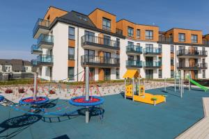 un parque infantil frente a un edificio de apartamentos en Sunny Apartments in Bel Mare Resort by Renters, en Międzyzdroje