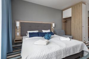 een slaapkamer met een groot bed met handdoeken erop bij Sunny Apartments in Bel Mare Resort by Noclegi Renters in Międzyzdroje +71 foto's