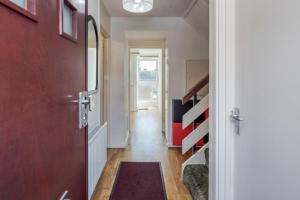 einen Flur mit einer roten Tür und einem roten Teppich in der Unterkunft 4-bedroom flat near BigBen,Parliament & London Eye in London