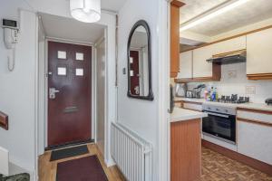 eine Küche mit einer Tür, die in eine Küche mit einer Theke führt in der Unterkunft 4-bedroom flat near BigBen,Parliament & London Eye in London