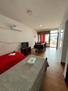 een slaapkamer met 2 bedden en een eetkamer met een tafel bij 4 Ases Hotel in Embalse