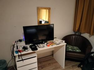 Cette chambre comprend un bureau avec une télévision et une chaise. dans l'établissement Tourist Travel Inn, à Schiedam