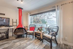 - un salon avec une cheminée rouge et des chaises dans l'établissement Stunning Water Front Cocooning et Spa 380, à Chertsey