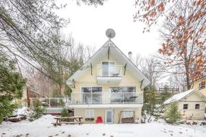 uma casa na neve com um telhado em Stunning Water Front Cocooning et Spa 380 em Chertsey