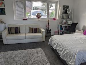 a bedroom with a white couch and a bed at Hawarden near Chester in Hawarden