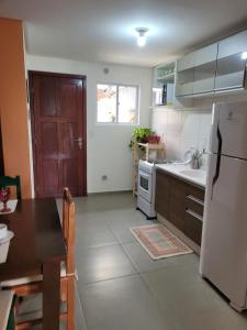 eine Küche mit einem weißen Kühlschrank und einem Tisch in der Unterkunft Sobrado em ótima localização. in Criciúma