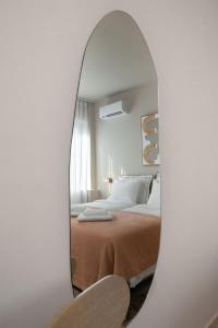 a bedroom with a bed and a mirror at Num Suites & Lofts Athens in Athens