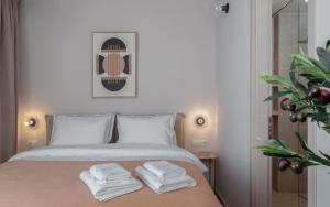 a bedroom with a bed with two towels on it at Num Suites & Lofts Athens in Athens