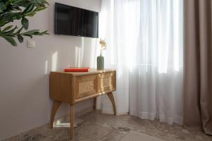 a table with a television on a wall next to a window at Num Suites & Lofts Athens in Athens